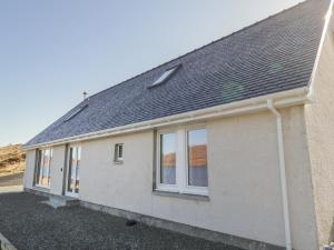 uma casa isolada com um telhado inclinado em Cuillin Shores em Luib