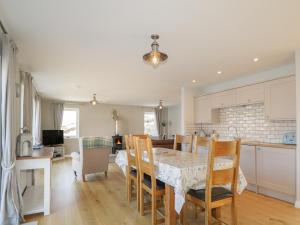 a kitchen and dining room with a table and chairs at Cuillin Shores in Luib