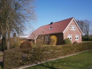 una casa in mattoni rossi con tetto rosso di Ferienwohnung Landleben 35195 a Hesel
