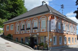 budynek z zegarem na boku w obiekcie Gasthof Brandlhof w mieście Wolfsegg am Hausruck