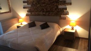 um quarto com uma grande cama branca e 2 candeeiros em ATTIC HOUSE - IL TUO ATTICO A RAPALLO em Rapallo