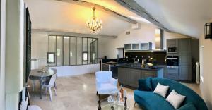uma cozinha e sala de estar com um sofá e uma mesa em La Bri...Gite em LʼIsle-sur-la-Sorgue