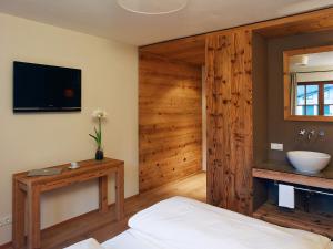 Schlafzimmer mit einem Bett, einem TV und einem Waschbecken in der Unterkunft Stallerhof in Golling an der Salzach