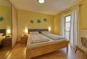 a bedroom with a large bed and a window at Ferienwohnungen Weghofer F**** (Viechtach) in Viechtach