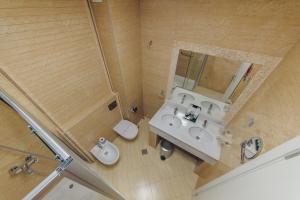ein Badezimmer mit einem Waschbecken, einem WC und einem Spiegel in der Unterkunft Vile Oliva Hotel & Resort in Petrovac na Moru