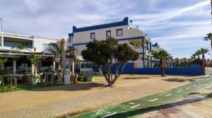 a building with a tree in front of a street at Lances playa in Tarifa