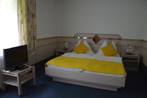 a bedroom with a large bed and a television at Gasthof Brandlhof in Wolfsegg am Hausruck