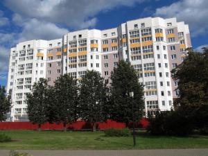 un gran edificio blanco con árboles delante de él en PaulMarie Apartments on Chigrinova 3, en Mogilev