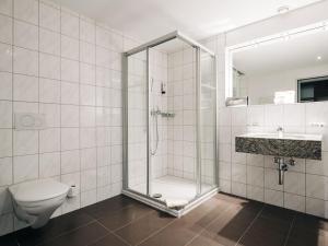 a bathroom with a shower and a toilet and a sink at Hotel Krone Thun in Thun