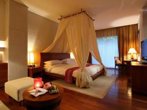 - une chambre avec un lit à baldaquin dans l'établissement Volando Urai Spring Spa & Resort, à Wulai