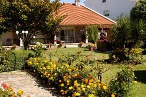 un jardín con flores frente a una casa en Duplex Playa de Rons en O Grove