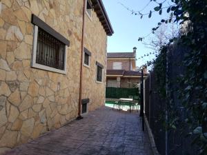 a stone building with a window and a table at Los Alisos Casa Rural in Guadalix de la Sierra