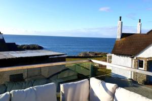 a view of the ocean from the balcony of a house at PLAS GWYN-3 BED-LUXURY SEA VIEW APT in Trearddur