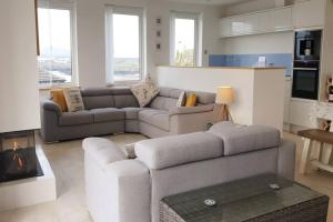 a living room with a couch and a table at PLAS GWYN-3 BED-LUXURY SEA VIEW APT in Trearddur