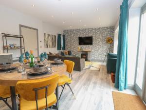 a dining room and living room with a table and chairs at The Old Rectory Coach House in Norwich