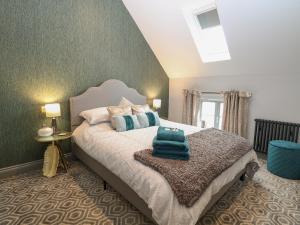 een slaapkamer met een bed met blauwe kussens erop bij The Old Rectory Coach House in Norwich