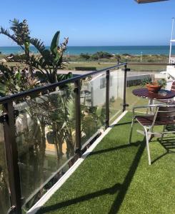 balcón con mesa, sillas y vistas al océano en Palm Beach Guesthouse, en Port Elizabeth