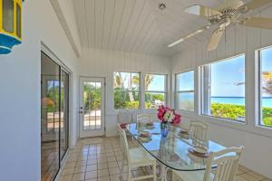 a dining room with a table and chairs and the ocean at Northside Grand Cayman Getaway with Private Beach! in North Side