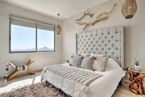 a bedroom with a large bed with a large window at Luxe Cabo Condo w/ Ocean Views + Amenities! in Cabo San Lucas +26 photos
