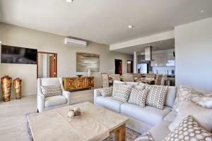 a living room with couches and a dining room at Luxe Cabo Condo w/ Ocean Views + Amenities! in Cabo San Lucas