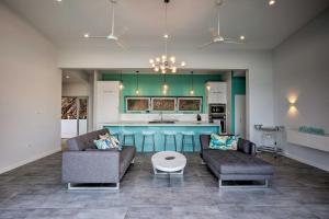 SlobにあるLuxury St Croix Home with Oceanfront Pool and Viewsのリビングルーム(ソファ2台付)、キッチンが備わります。