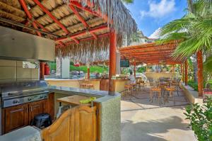 an outdoor kitchen with a grill and a table with chairs at Resort-Style Cabo Getaway with Pools & Ocean Views in Cabo San Lucas