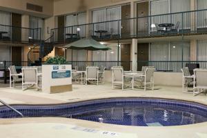 a pool with chairs and a table and an umbrella at Holiday Inn Alexandria, an IHG Hotel in Alexandria