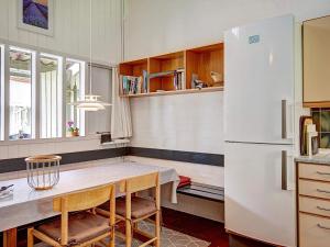 a kitchen with a table and a white refrigerator at 7 person holiday home in Allinge in Allinge
