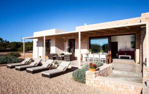 a patio of a house with couches and a table at Casa Lavanda in Cala Saona