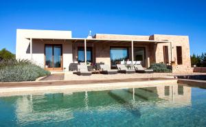 a house with a swimming pool in front of a house at Casa Lavanda in Cala Saona