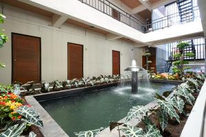 a pool with a fountain in the middle of a building at Euanjitt Chill House in Khon Kaen
