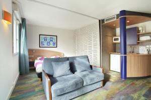a living room with a couch and a bedroom at Suite-Home Orléans-Saran in Saran +26 photos