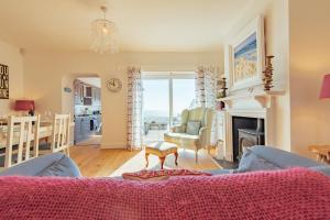 ein Wohnzimmer mit Couch und Tisch und eine Küche in der Unterkunft Driftwood Cottage by Bloom Stays in Folkestone