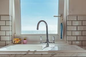 a sink in a kitchen with a window at Driftwood Cottage by Bloom Stays in Folkestone