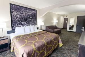 um quarto de hotel com uma cama grande e uma cadeira em Super 8 by Wyndham High Point/Greensboro em High Point