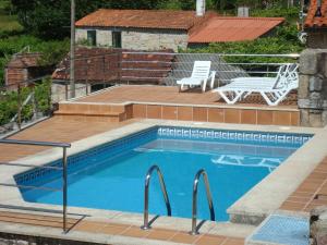 uma pequena piscina com um deque e um pátio em CASA RURAL LAR DE VILARINO em Poio