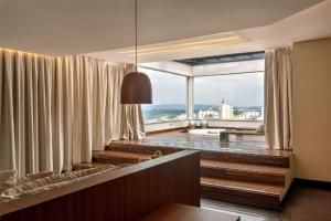 a living room with curtains and a large window at Tryp by Wyndham Varginha Cafe Royal in Varginha