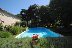 a swimming pool in a yard with flowers in a pot at Manoir du Bois Mignon Luxury Home - Dordogne in Le Fleix +14 photos