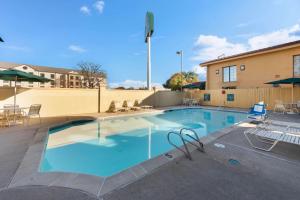 a large swimming pool with chairs and a building at La Quinta Inn by Wyndham Bossier City in Bossier City