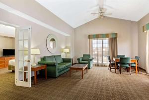 a living room with a couch and a table and chairs at La Quinta Inn by Wyndham Denver Northglenn in Westminster