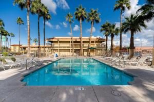 a swimming pool with palm trees and a building at La Quinta Inn by Wyndham Phoenix Thomas Road in Phoenix