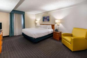 a hotel room with a bed and a chair at La Quinta Inn by Wyndham Phoenix Thomas Road in Phoenix