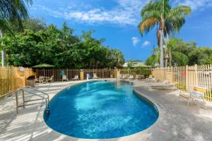 uma piscina com cadeiras e uma cerca em La Quinta Inn by Wyndham Ft. Lauderdale Tamarac East em Fort Lauderdale