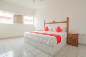 OYO Hotel Morelos, Villa Hidalgo في Villa Hidalgo: غرفة نوم بسرير كبير ومخدات حمراء