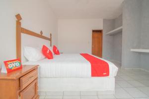 OYO Hotel Morelos, Villa Hidalgo في Villa Hidalgo: غرفة نوم عليها سرير ومخدات حمراء
