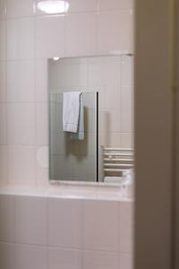 einen Spiegel im Bad mit einem weißen Handtuch in der Unterkunft Skotel The Hague, Hotelschool The Hague in Scheveningen