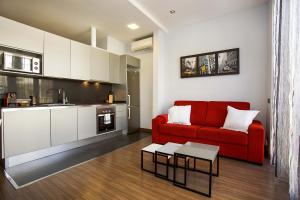 een woonkamer met een rode bank en een keuken bij PobleNou Loft Nº2 By MyRentalHost in Barcelona