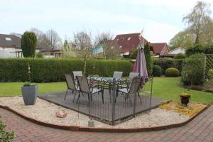 a patio with a table and chairs and an umbrella at Ferienwohnung Hooge Loogen, 35212 in Holtland