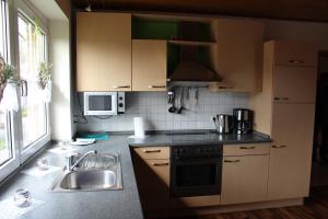 a kitchen with a sink and a stove at Ferienwohnung Hooge Loogen, 35212 in Holtland