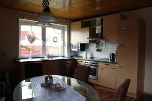 a kitchen with a table and a dining room at Ferienwohnung Hooge Loogen, 35212 in Holtland